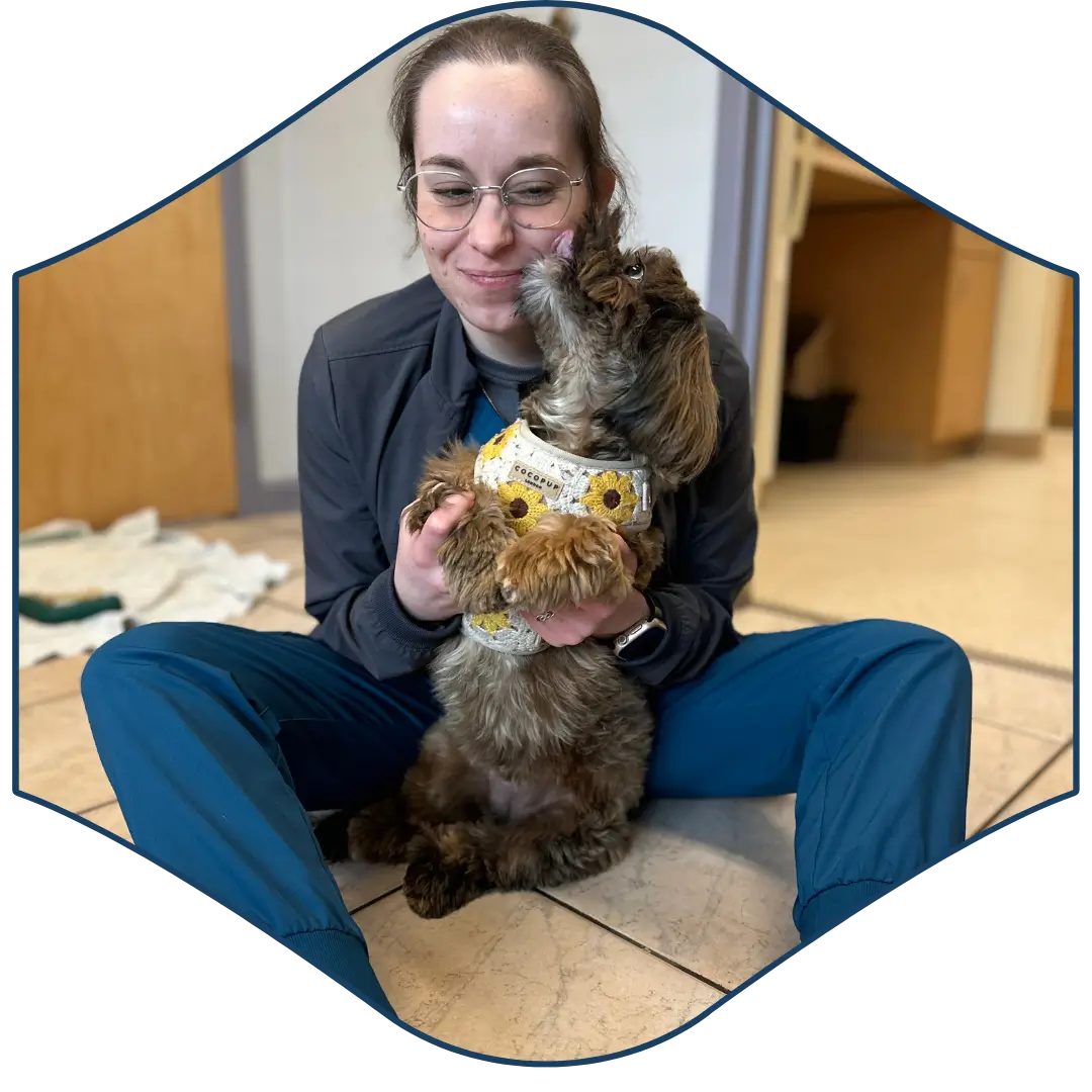 a person sitting on the floor holding a dog