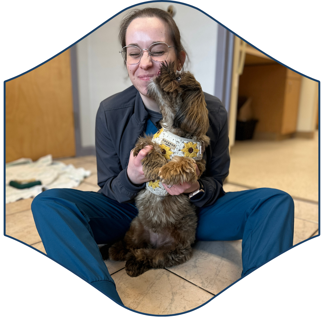 A person sitting on the floor holding a dog