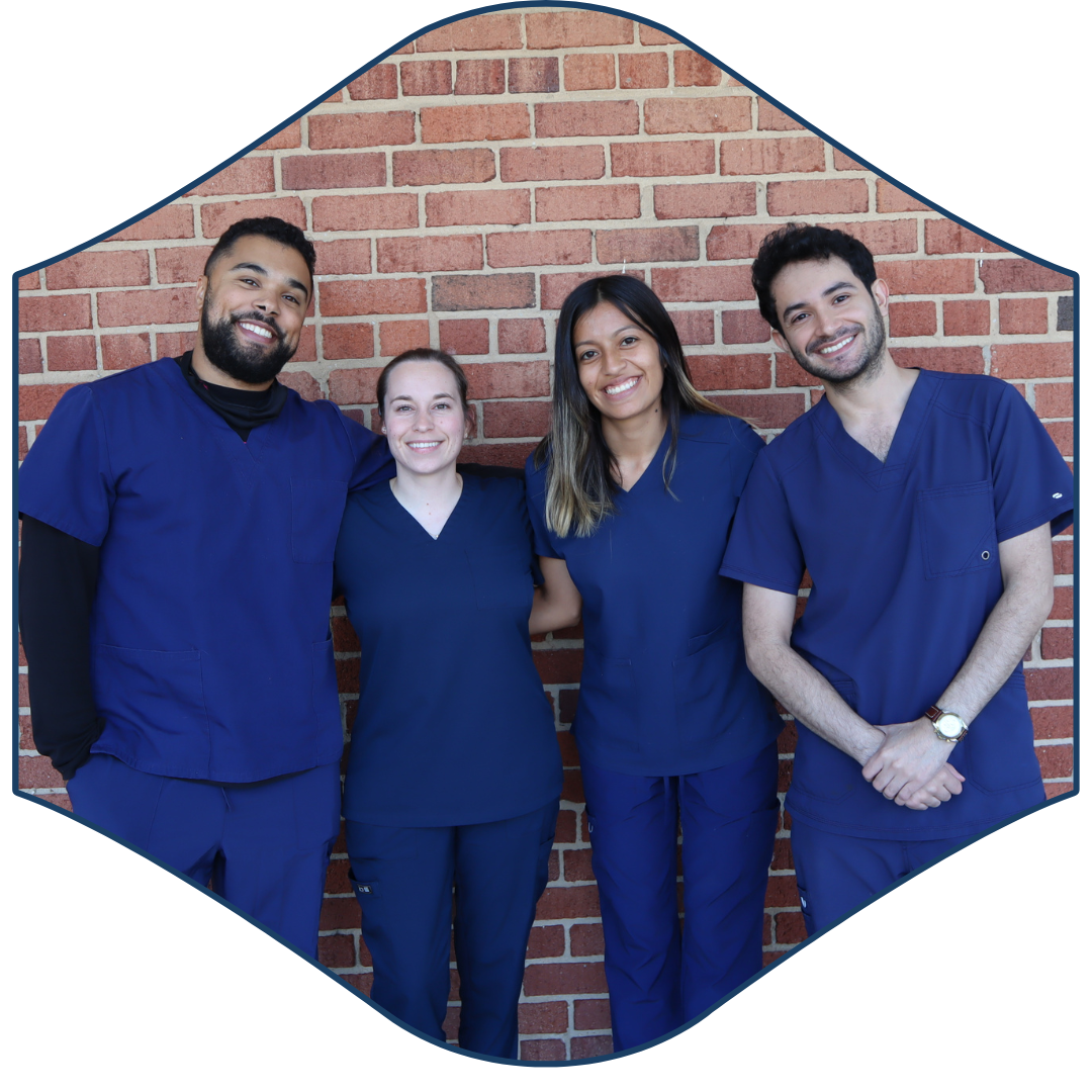 people in scrubs standing in front of a brick wall